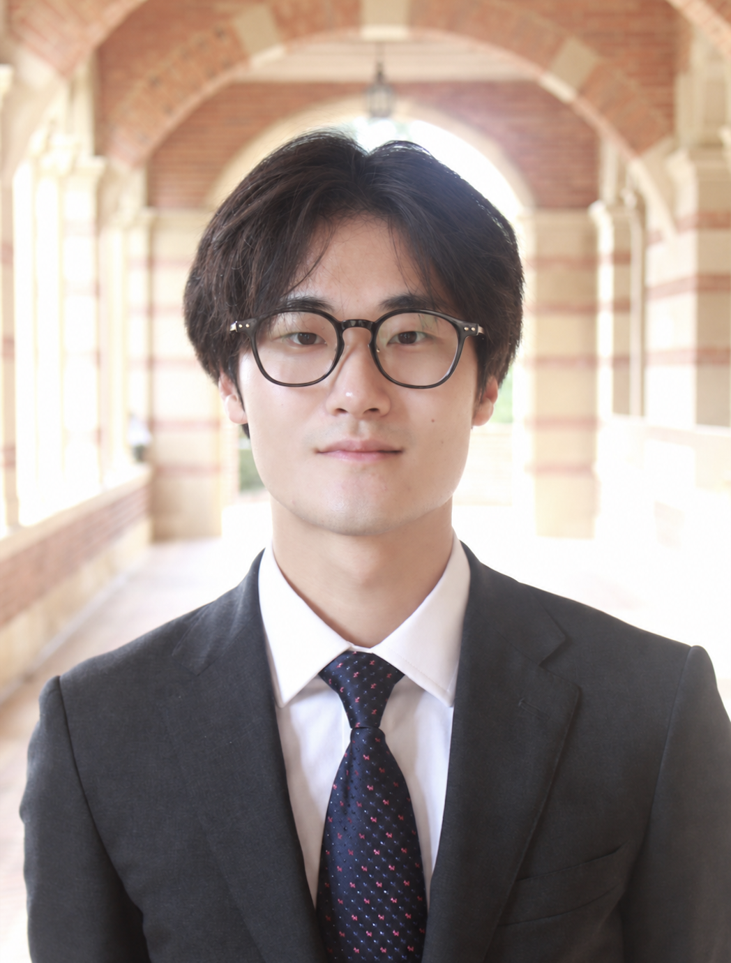 Jin Kim wearing glasses and a suit at UCLA.